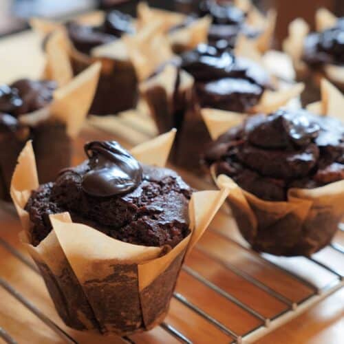 Decadent chocolate muffins cooling on a rack.