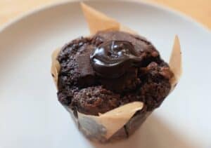 Chocolate muffin with fudge filling oozing out of the top.