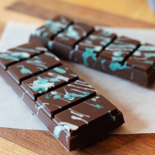 Two, five-sectioned chocolate bars with white/blue splatter pattern on top.